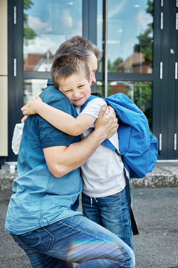 Back to school. dad sees off, hugs the child before the start of lessons. the new school year. 
