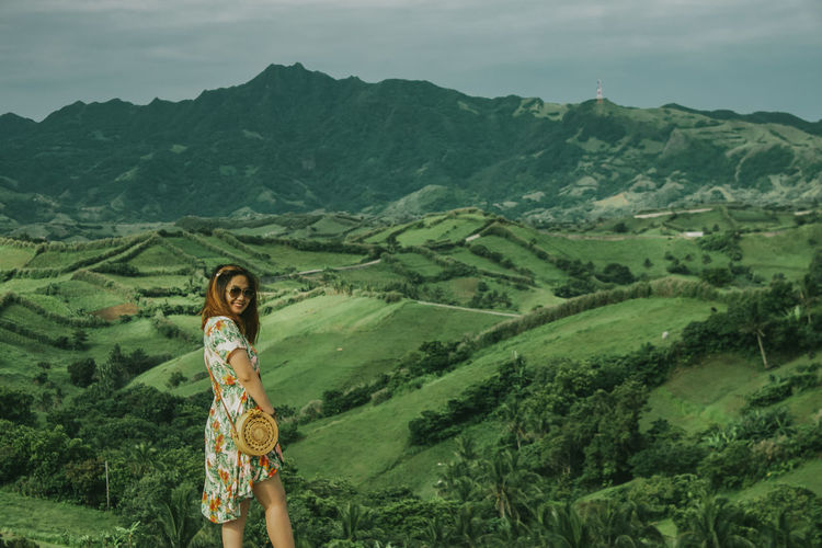 Portrait of woman standing on mountain landscape