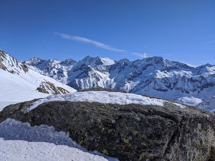 Scenic view of snowcapped mountains against blue sky