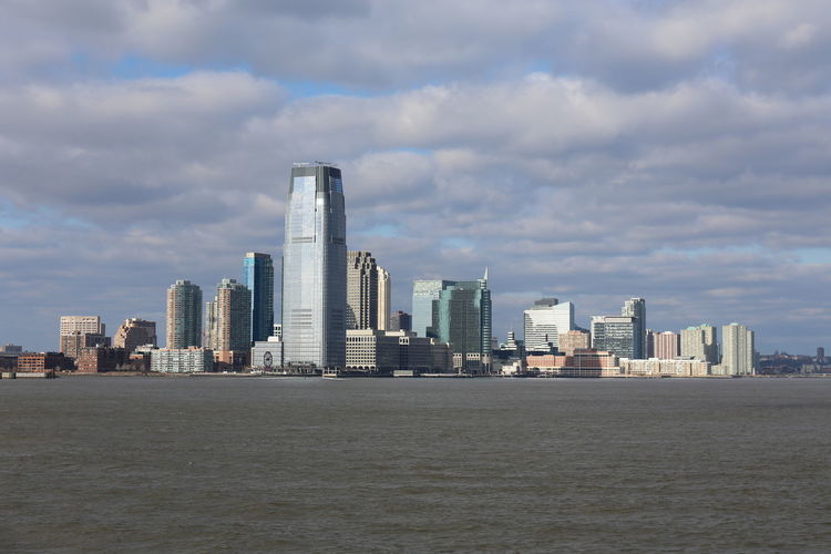 Modern buildings in city against cloudy sky