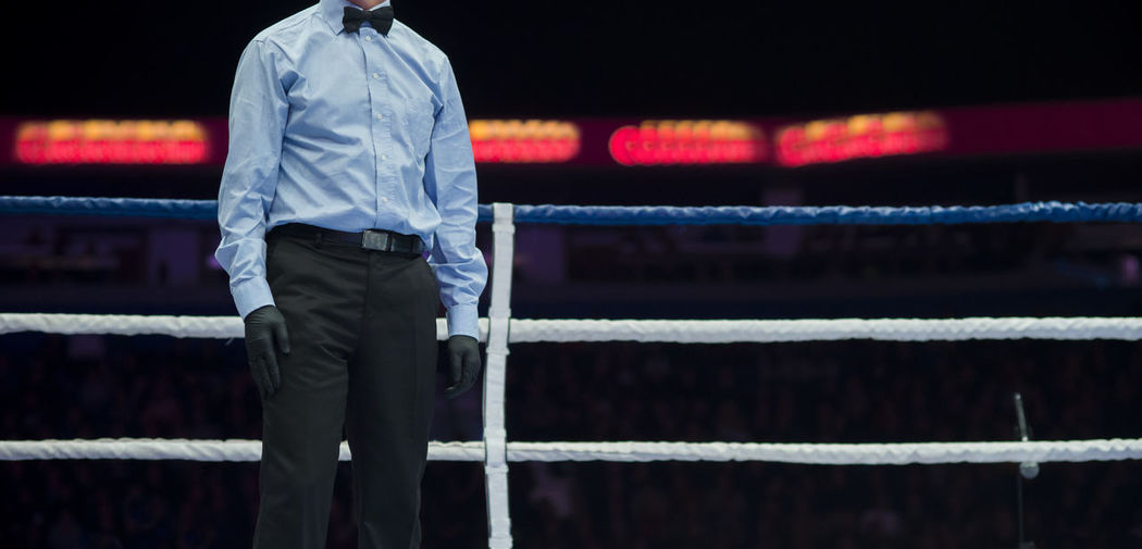 Midsection of referee standing in boxing ring
