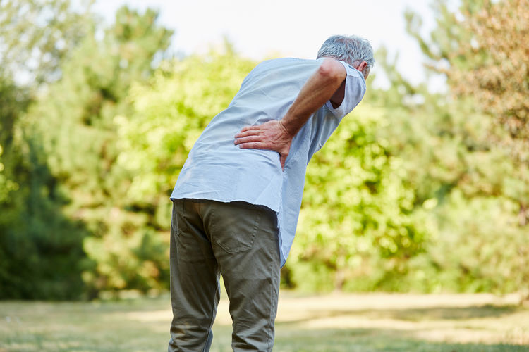 Senior man suffering from backache at park