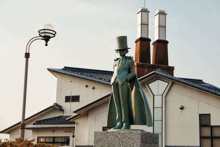 Low angle view of statue in city against sky