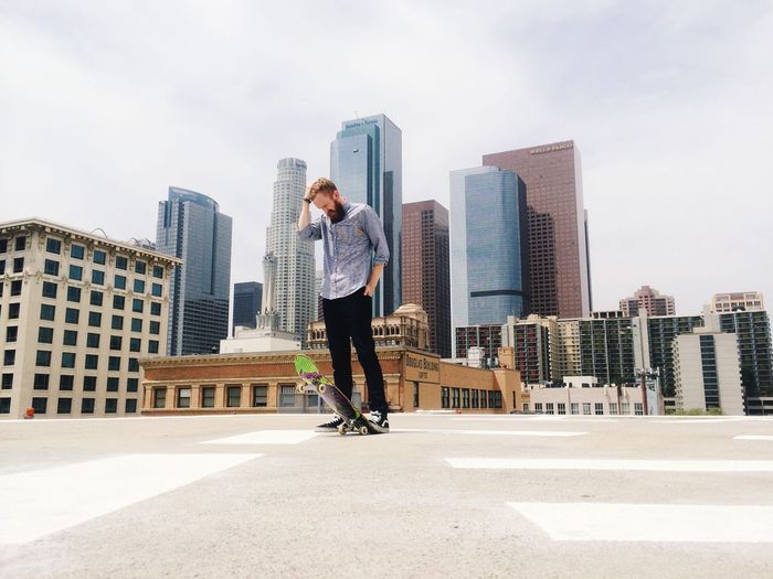 Man standing on rooftop with skateboard
