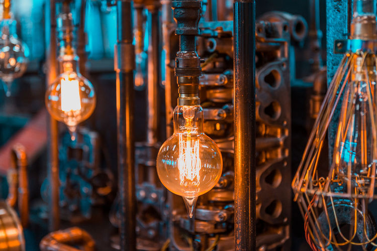 Illuminated light bulbs hanging in factory