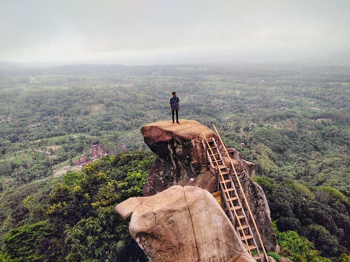 Full length of man standing on rock against landscape