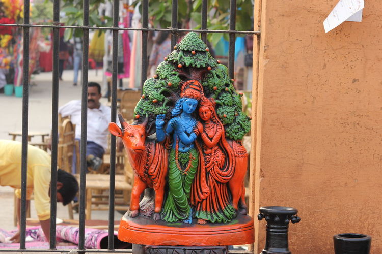 Statue of radha and krishna by railing