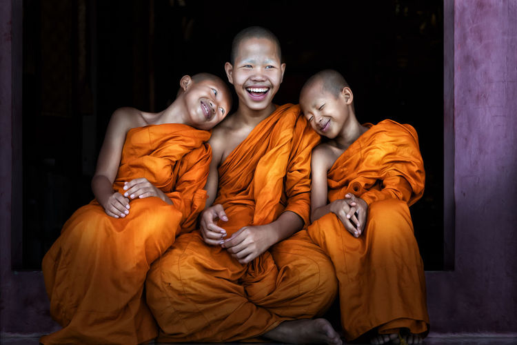 Cheerful monks sitting outdoors