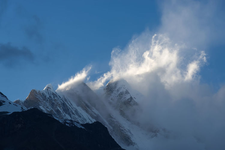 Low angle view of snowcapped mountains against sky