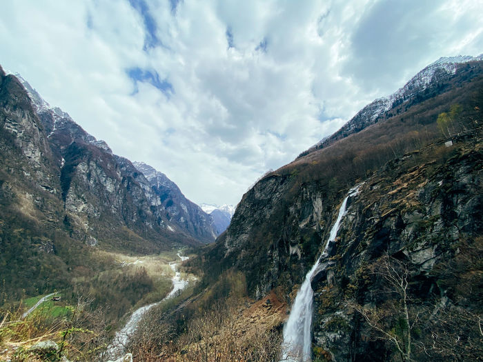 Panoramic view of mountains against sky with waterfall 