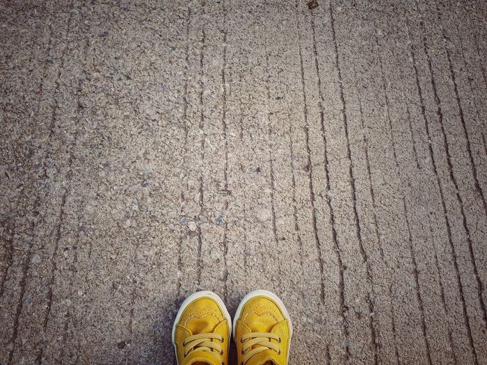 Yellow shoes on footpath