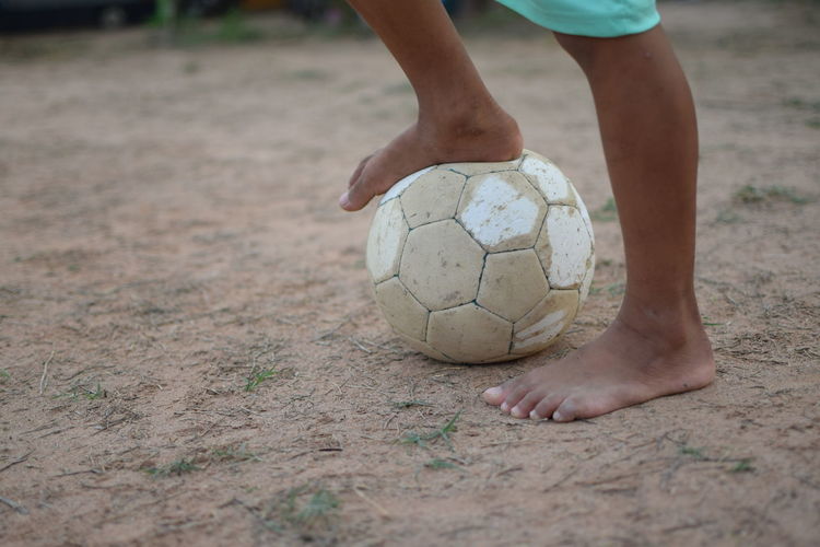 Low section of boy playing soccer ball