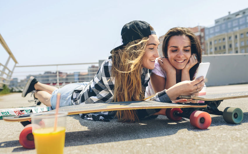 Two young women with longboards enjoying summer