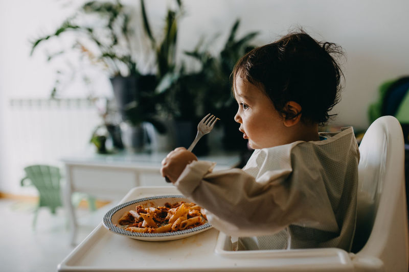 Midsection of child eating with fork