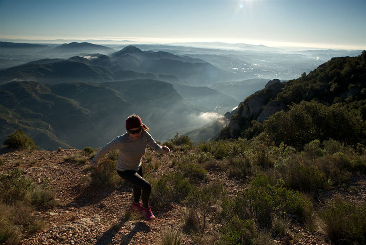 Woman runs through the mountains of montserrat in catalonia, spain.