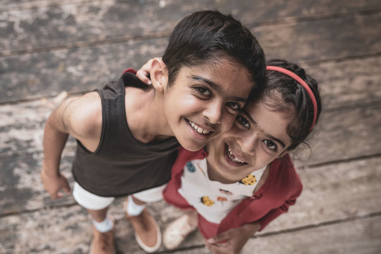 High angle portrait of smiling siblings standing outdoors