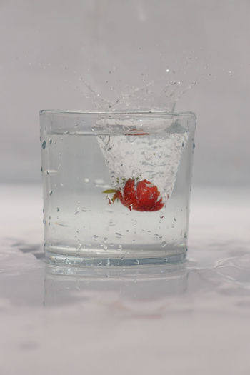 Close-up of fruit on glass against white background