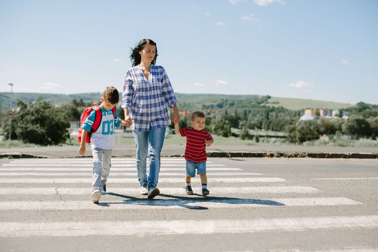 Full length of mother and children on zebra crossing
