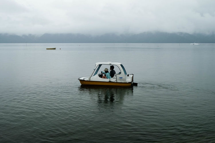 Man and woman riding motorboat on caldera lake at akan national park