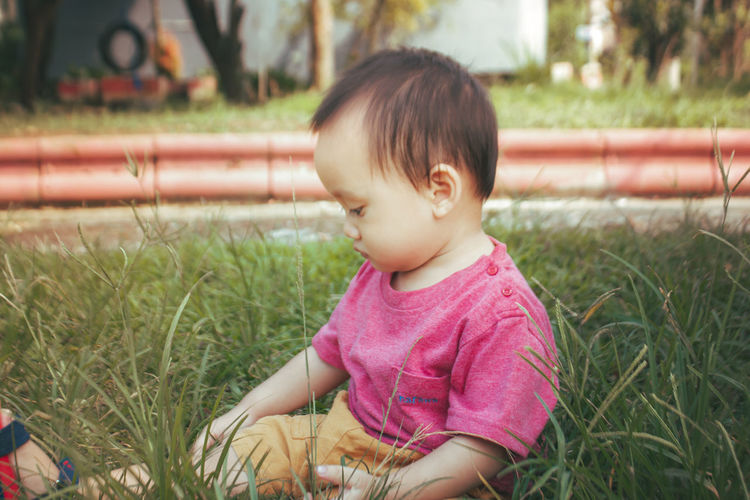 Cute baby girl sitting on field