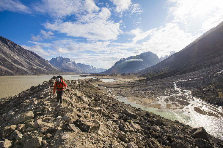Hiker carefully traverses top of a glacial moraine in akshayak pass.