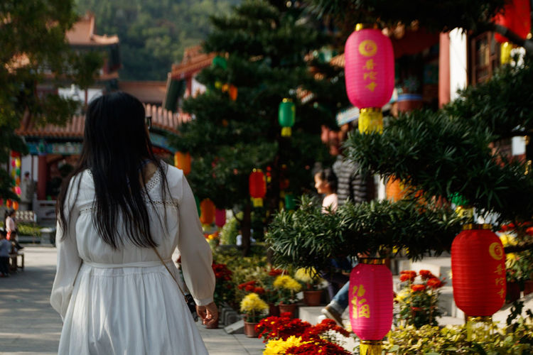 Rear view of woman standing by plants