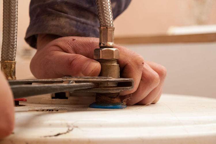 Flat renovation, plumber, puts hemp thread around the valve