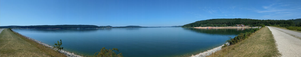 Panoramic view of lake against clear blue sky