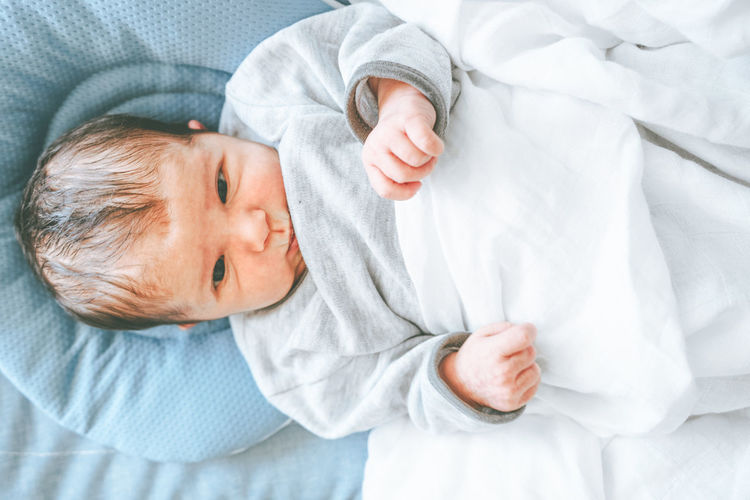 Portrait of cute baby lying on bed