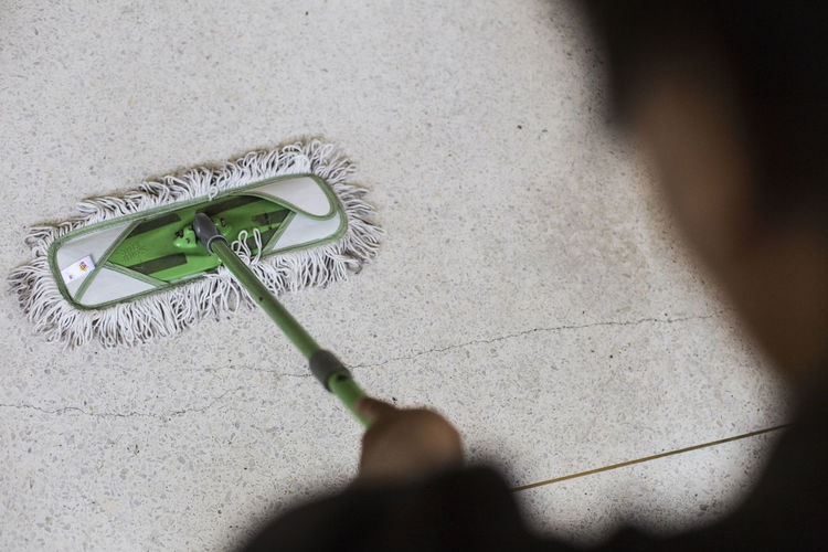 Cropped image of person cleaning floor with mop