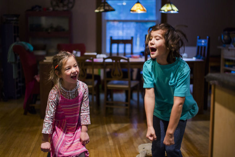 Siblings laughing and singing together at home