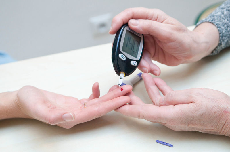 Cropped image of female doctor performing diabetes test on patient at hospital