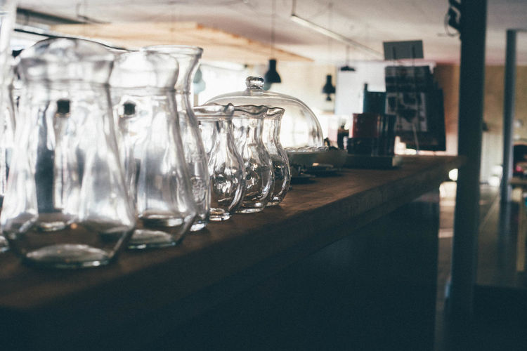 Empty glass jugs on counter at bar