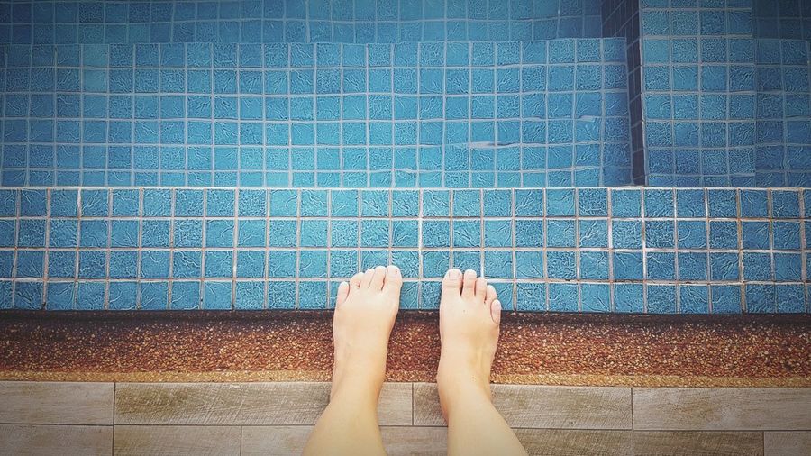 Low section of woman legs in swimming pool