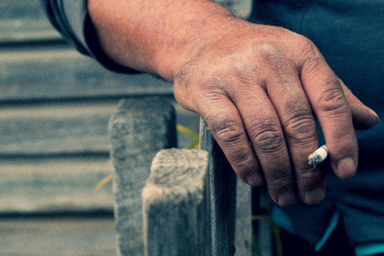 Close-up of man holding cigarette
