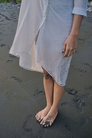 Low section of woman standing on beach
