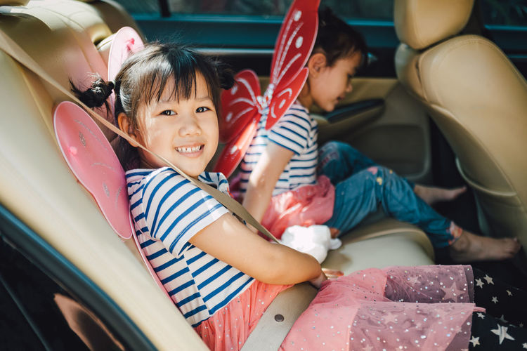 Portrait of cute kids sitting in car