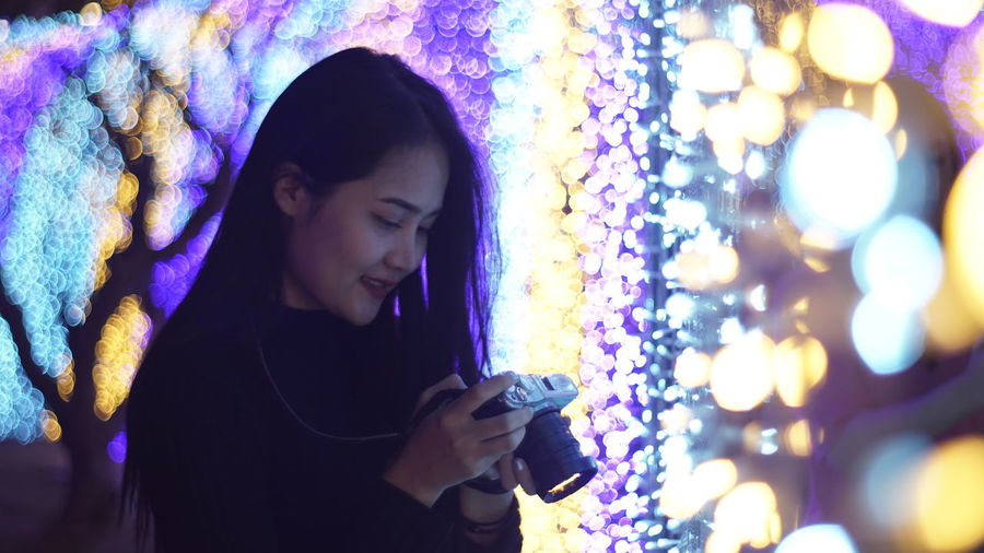 Close-up of young woman using smart phone at night