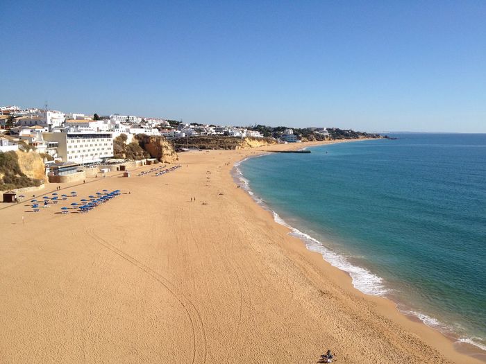 Scenic view of beach against clear blue sky
