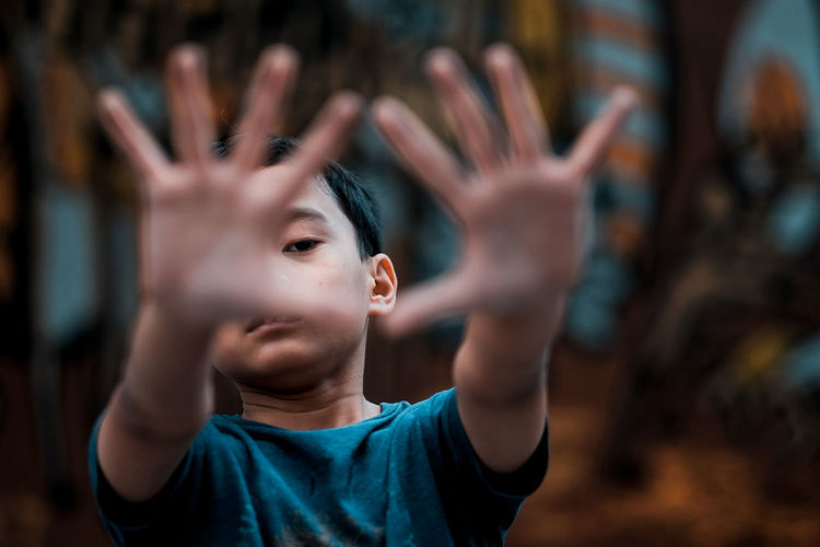 Portrait of boy gesturing while standing outdoors