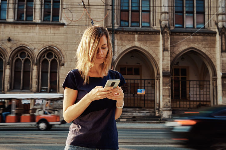 Woman using smartphone at city street