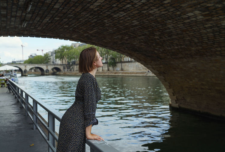 Woman standing on bridge over river