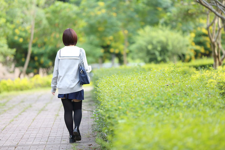 Rear view of woman in school uniform at park