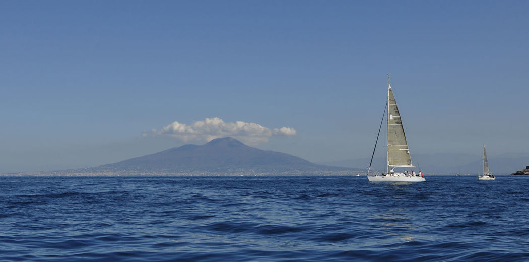 Sailboat sailing on sea against blue sky