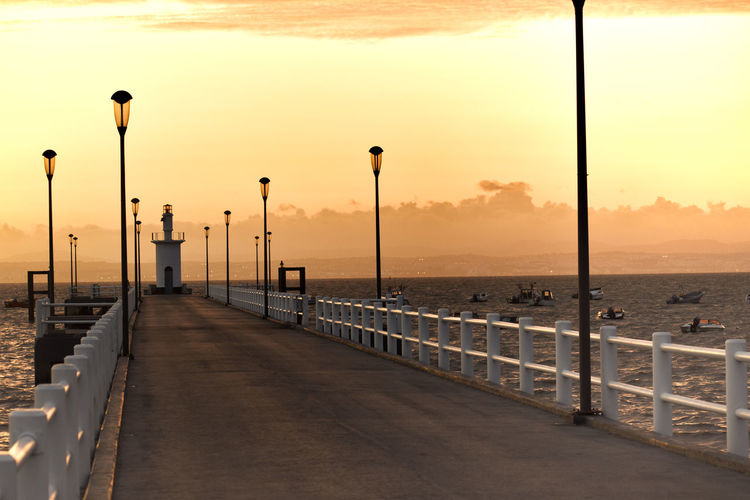 View of bridge by sea against sky during sunset