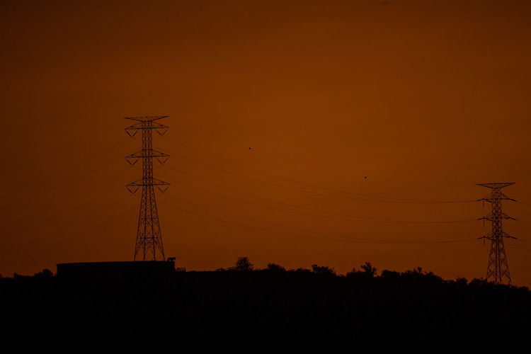 Electricity pylon against sky during sunset