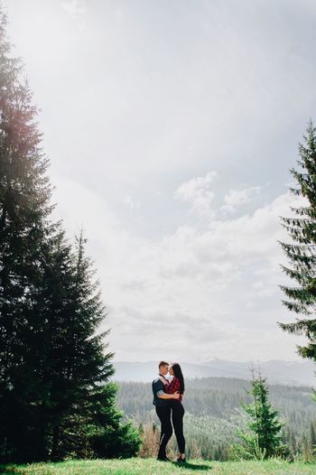 Full length of young couple standing face to face in forest