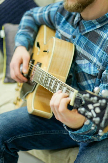 Midsection of boy playing guitar