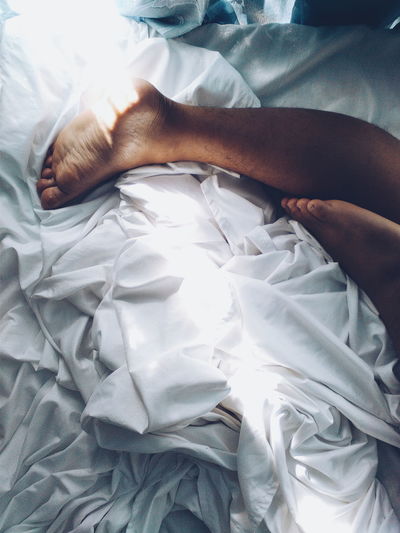 Low section of person relaxing on bed