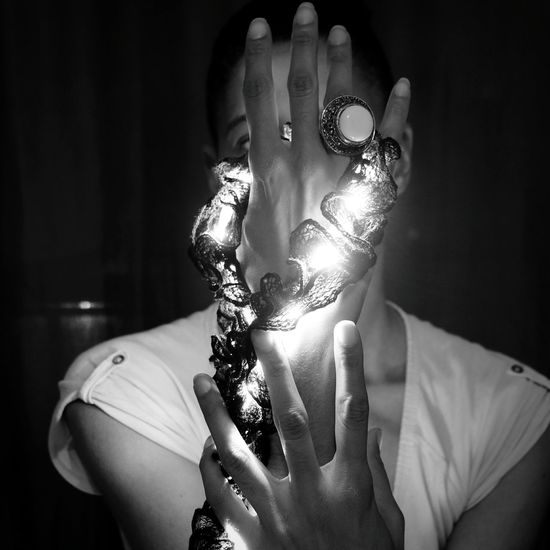 Close-up of woman illuminated led lights in darkroom